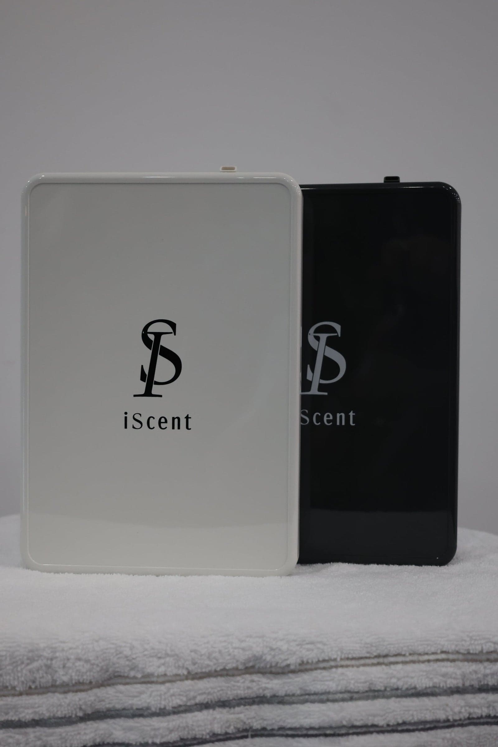 White iScent Pro cold-air fragrance diffuser styled on a console in a bright modern living room